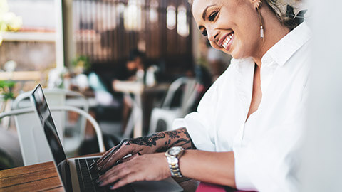 An accountant typing information into a laptop in a relaxed environment