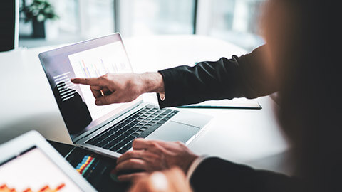 A close view of an accountant entering data into a laptop