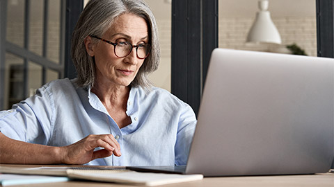 An older person working remotely on their laptop