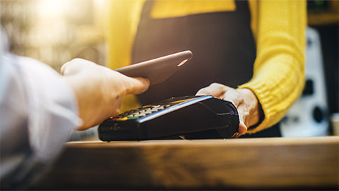 A merchant taking an EFTPOS payment from a smart phone belonging to one of their customers