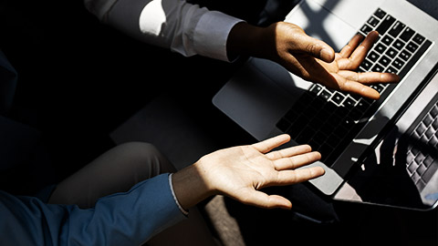 A pair of employees discussing something on a laptop