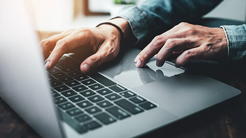 A close view of a person typing on a laptop