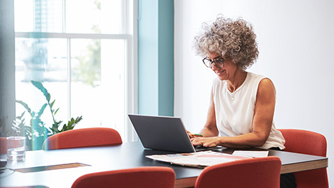 A wide shot of an accountant working on a laptop