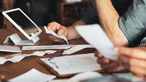 A close view of business owners looking at invoices