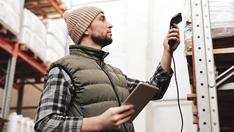 A person scanning an item in a warehouse