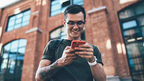 A young hipster checking online banking on his phone