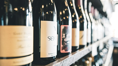 A close view of wine bottles on a shelf