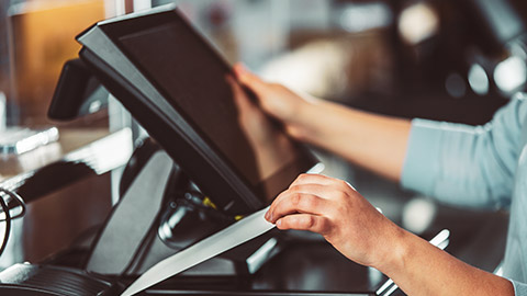 A business owner printing out receipts from a cash register