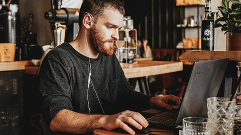 A small business owner sitting at a desk working on a business document on a laptop