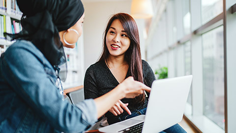 2 young work colleagues communicating about a jobn