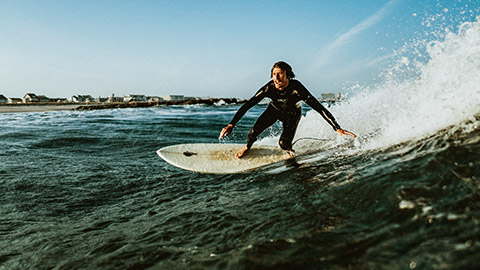 A male surfer ripping into a turn on a smallish wave