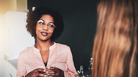 A business professional actively listening to a colleague while smiling