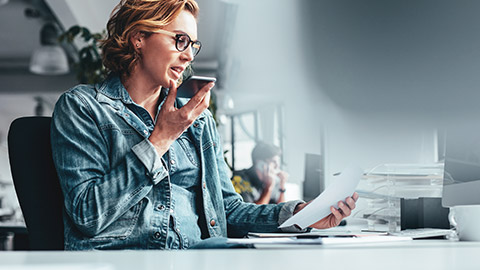 A business owner discussing a document with a colleague on the phone