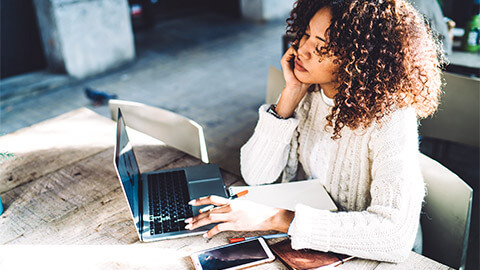 A young professional seated at their desk, reflecting on their own work performance and areas that they could improve in