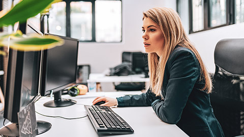 A BAS agent working on tax jobs in front of 2 screens