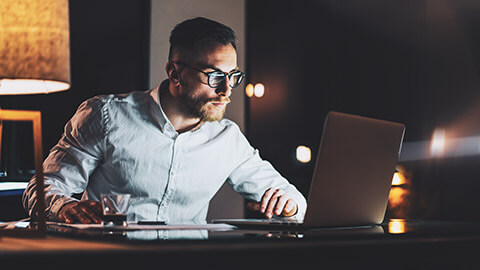 A manager reading legislation on a laptop computer