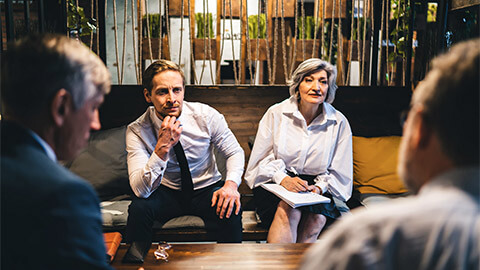 A group of stakeholders holding an informal meeting around a common area in their office space