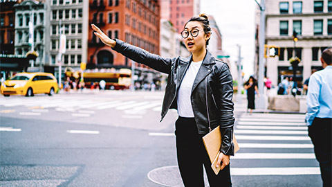 A marketing executive hailing a taxi, making their way to a client meeting