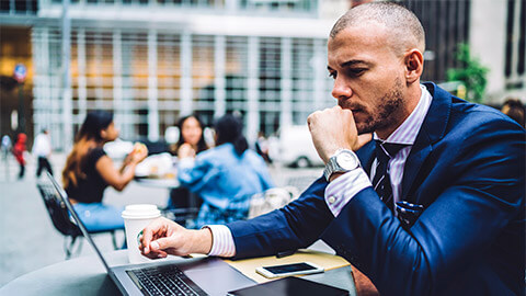 A professional seated at a table, proofreading documents for their organisation