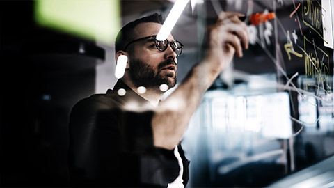 A person looking at and identifying something in the glass board