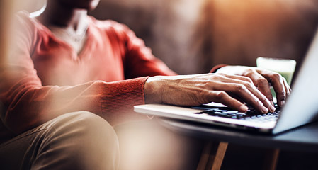 a person typing in a laptop