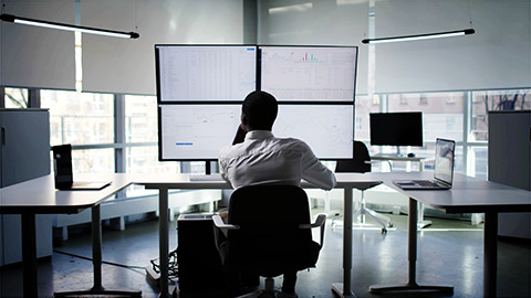 a person digesting big data sources on multiple screens