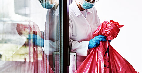 A veterinarian disposing of biohazard materials properly