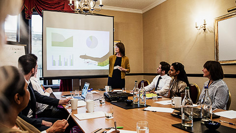 A leader presenting various graphs and figures to staff.