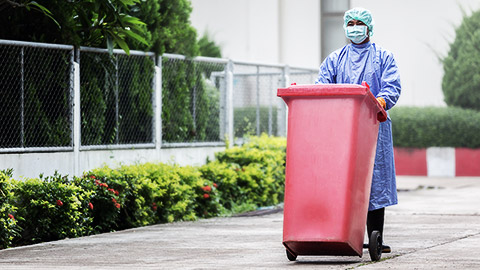 A medical professional disposing biohazardous out of the building