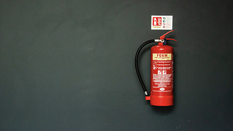 A single fire extinguisher hanging on a wall