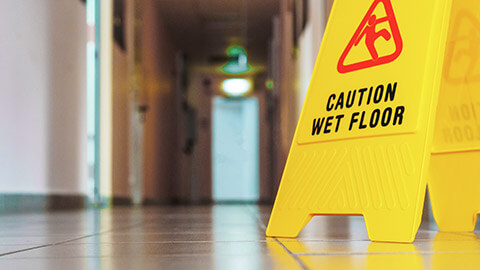 A close view of a sign warning of a slippery floor