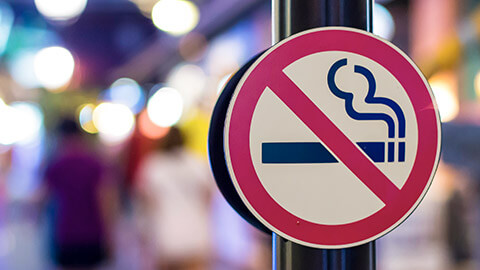 A no smoking sign in a busy pedestrian area