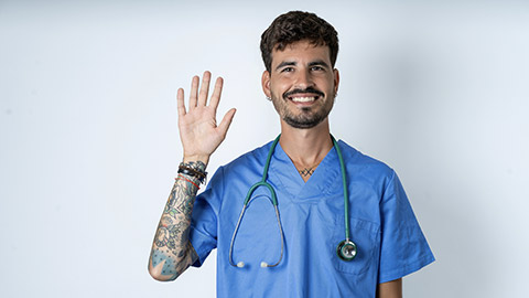 young caucasian doctor man wearing blue medical uniform showing and pointing up with fingers number five while smiling confident and happy.