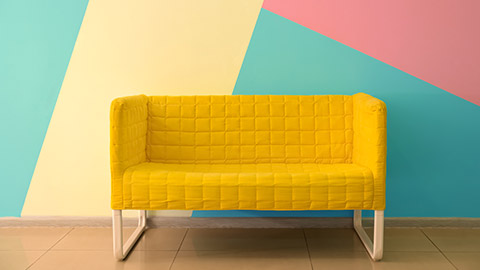 A colourful chair in front of a mult-coloured wall