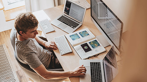 Top down view of a designer working on multiple screens