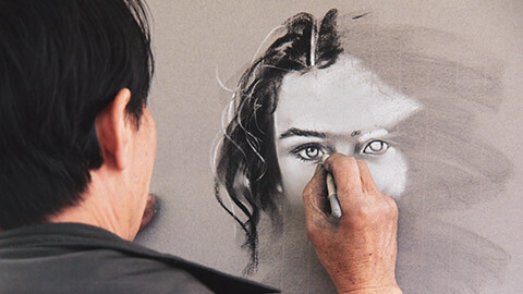 Over-the-shoulder view of an artist doing a portrait