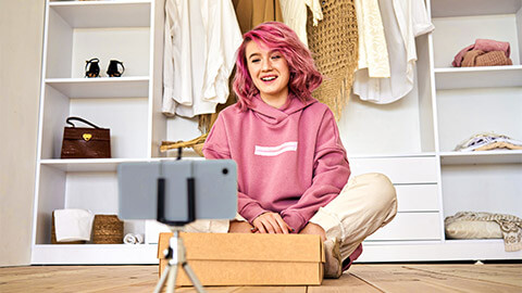 A social media influencer creating an unboxing video with a package they just received