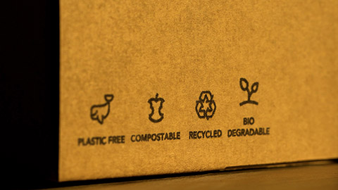 The markings on a cardboard box, indicating a package's sustainability and recyclability