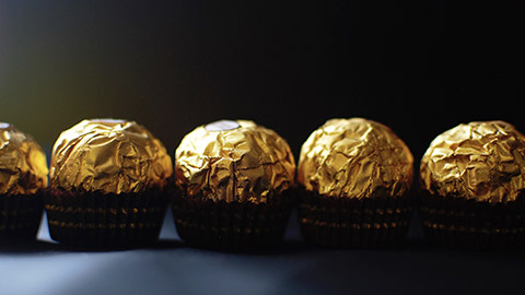 A lineup of chocolates with foil wrapping