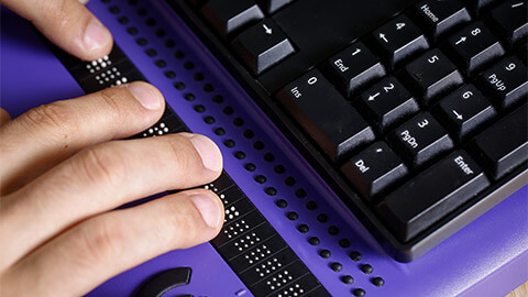 A person with a visuale impairment using assistive technology to access a website.