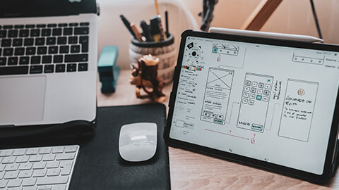 A tablet with UX design software and a project visible on the screen
