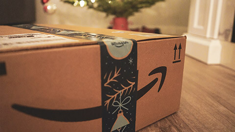 A close view of an Amazon box near a christmas tree