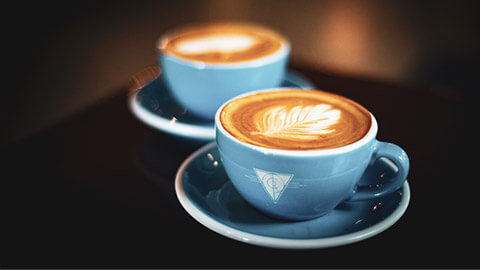 A close view of 2 coffee cups on a table