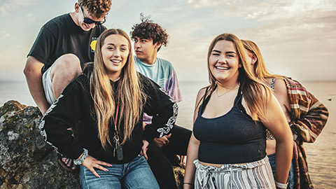 A group of teenagers hanging out at the beach