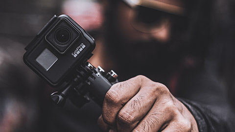 A close view of a person holding a GoPro camera