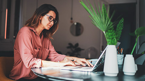 A marketing executive working on campaign costs on a laptop