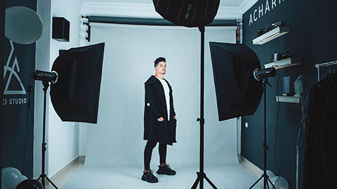 A model posing for images in a studio with moody lighting