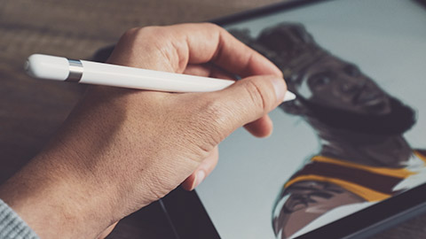 A close view of an illustrator working on a piece on a digital tablet