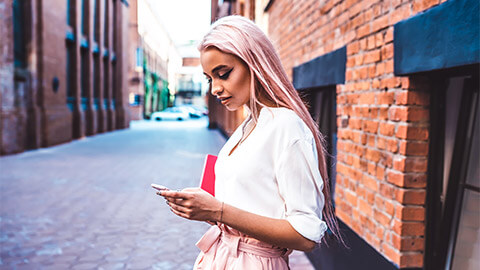 A person on their daily commute, engaging with their smart phone along the way