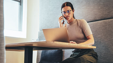 A entrepreneur sitting at a table talking on the phone to a client